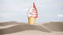 Ice cream cone with red and white swirls on a sandy dune